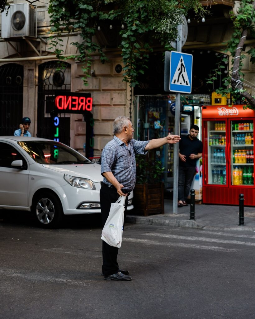 Baku Street Photography - An old man giving directions at the pedestrian crossing