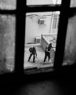 A photo showing workers hard at work from a broken window in a hotel in Baku